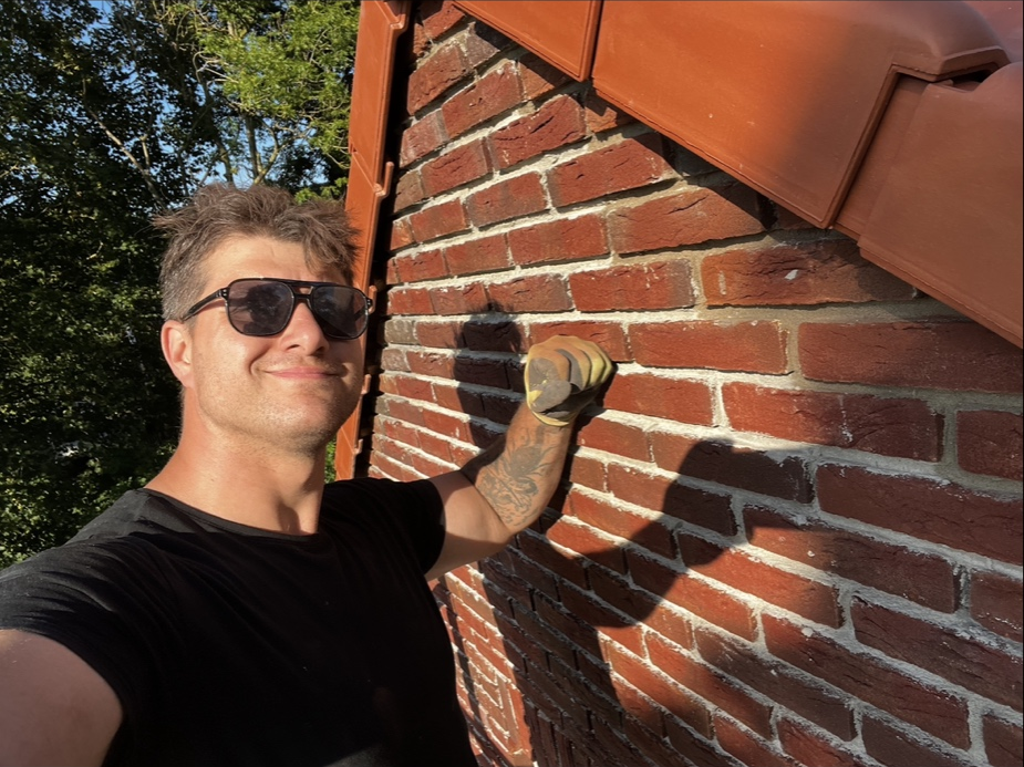 Vakman van Klussenbedrijf Korduba aan het werk aan een bakstenen gevel