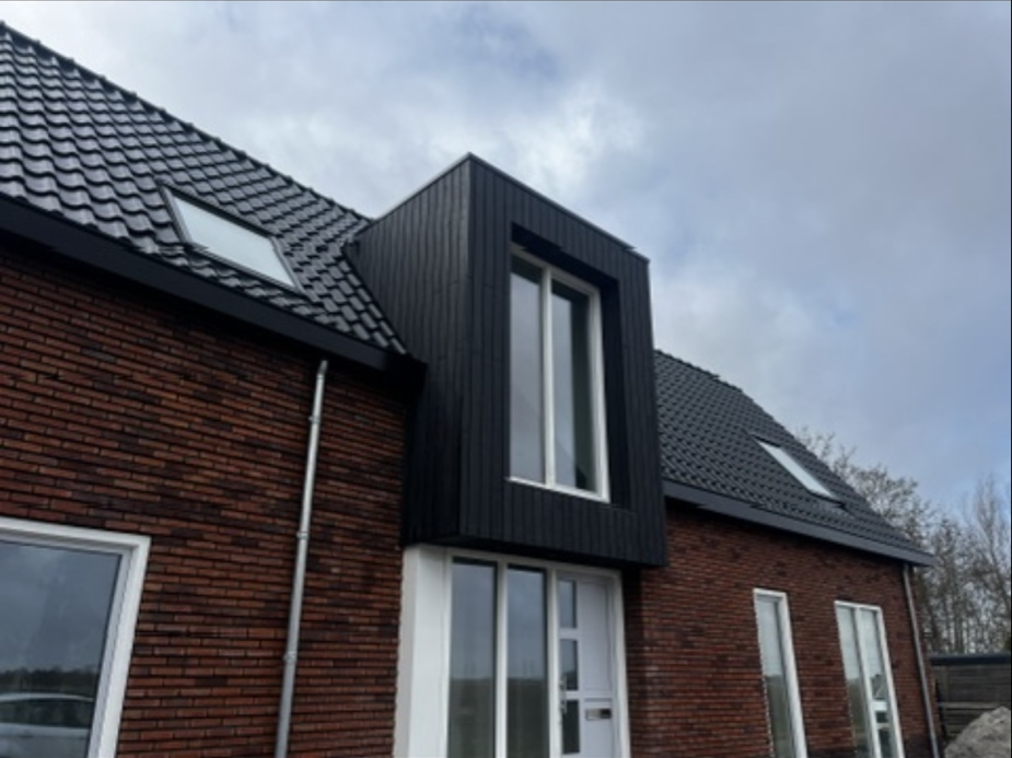 Afgewerkte dakkapel met dakraam in zwarte gevelbekleding